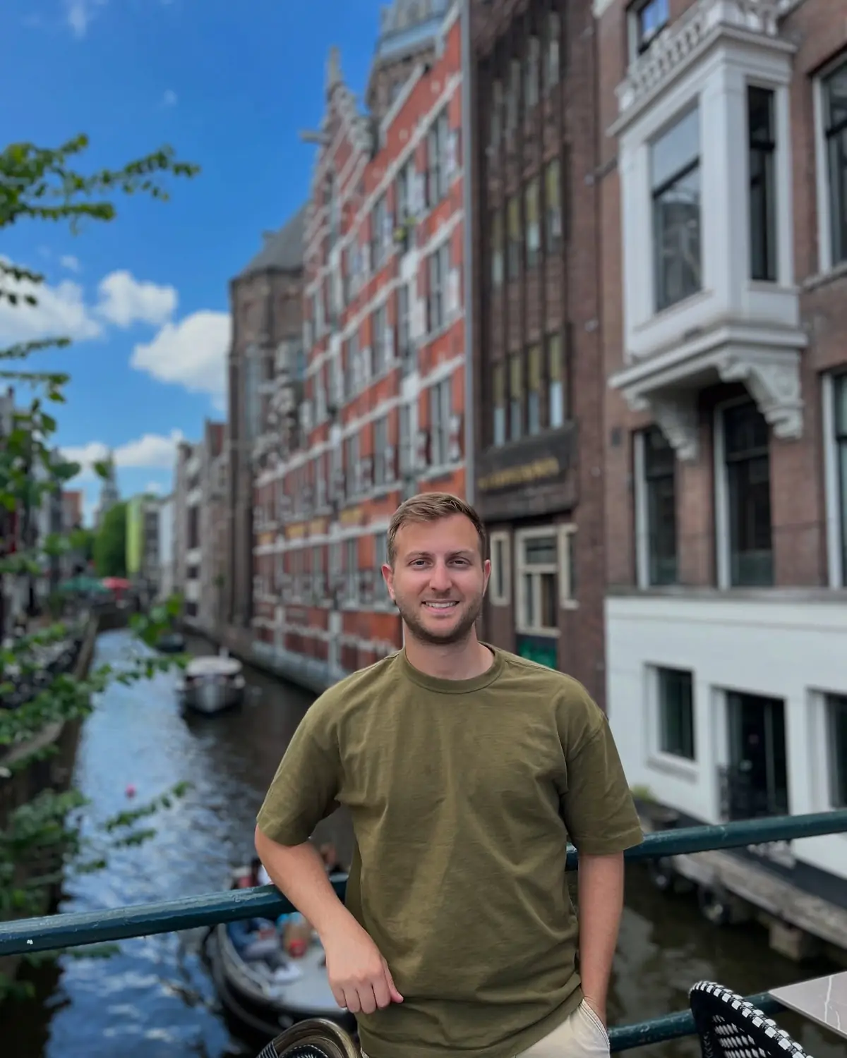 Andrew leaning on a railing above a narrow Amsterdam canal