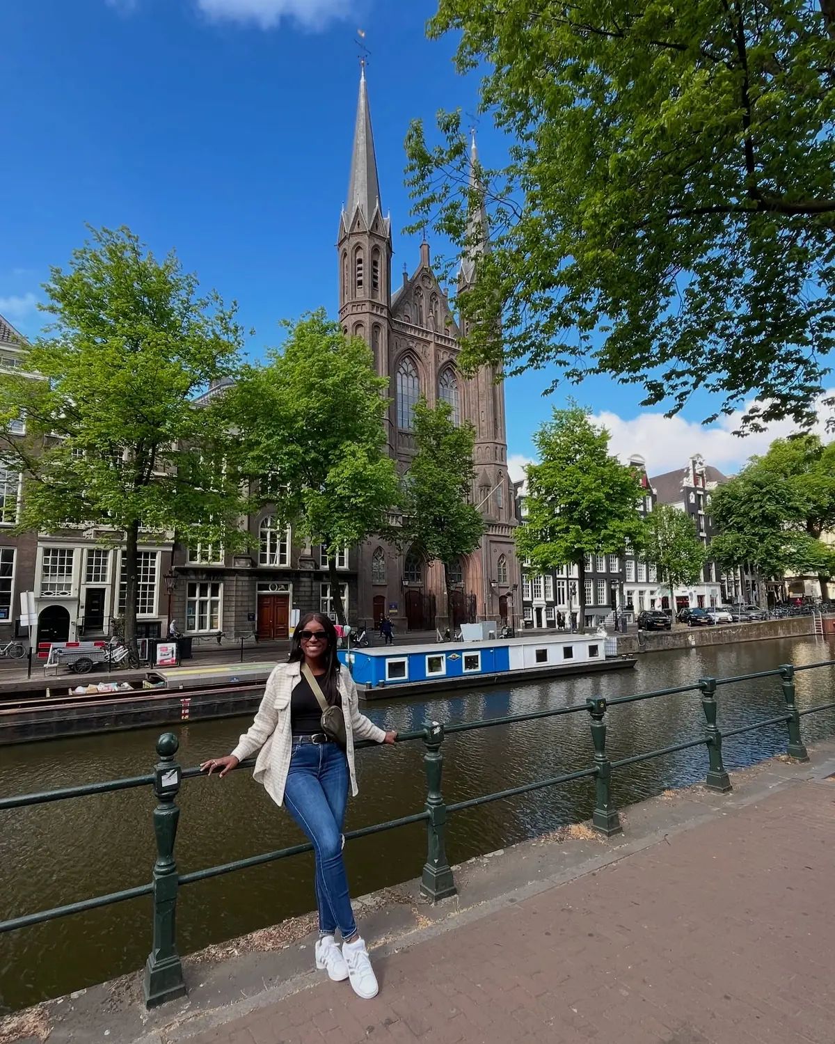 Melody by an Amsterdam canal with a Gothic church spire behind