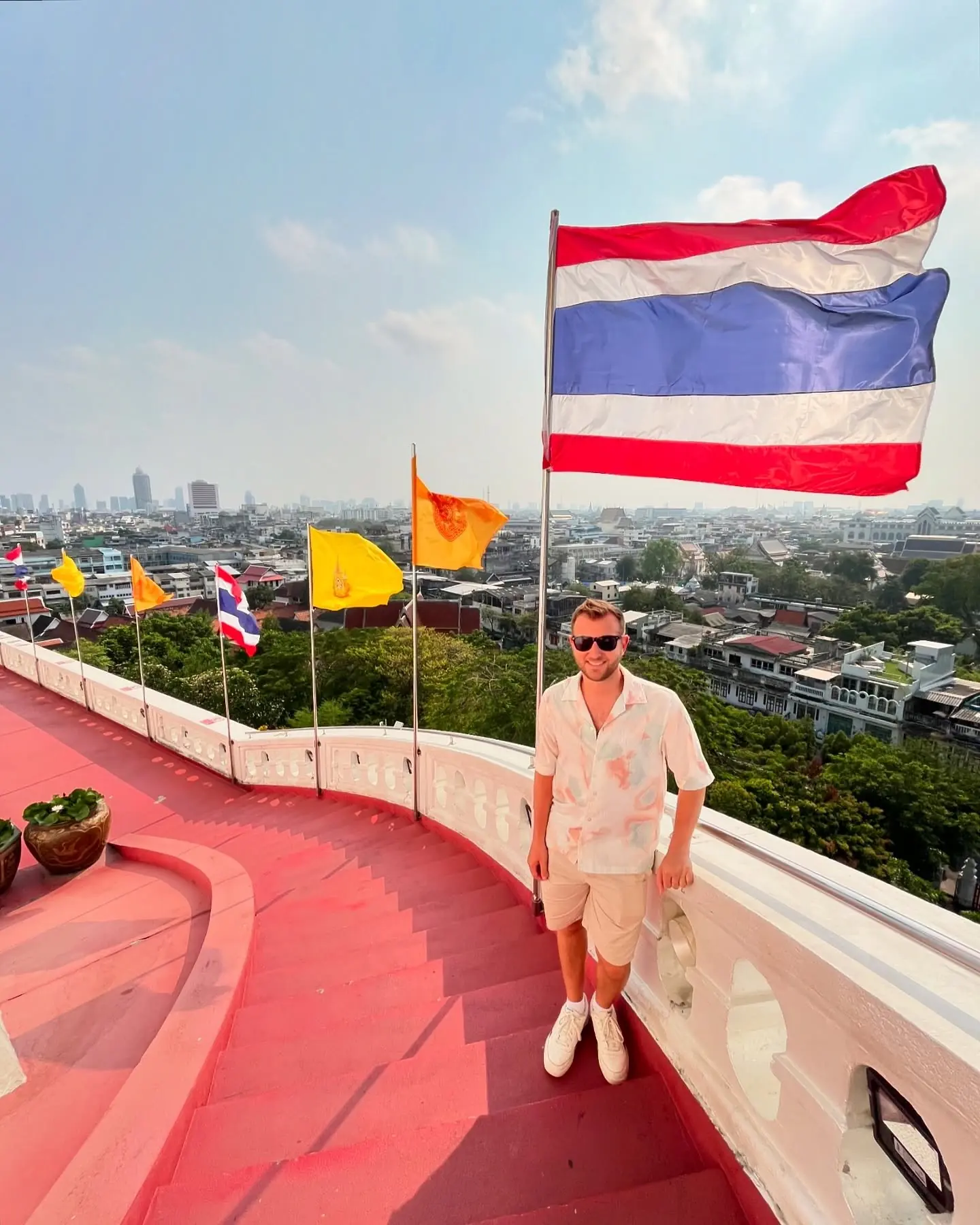 On the red terrace of the Golden Mount with Thai flags and the Bangkok skyline