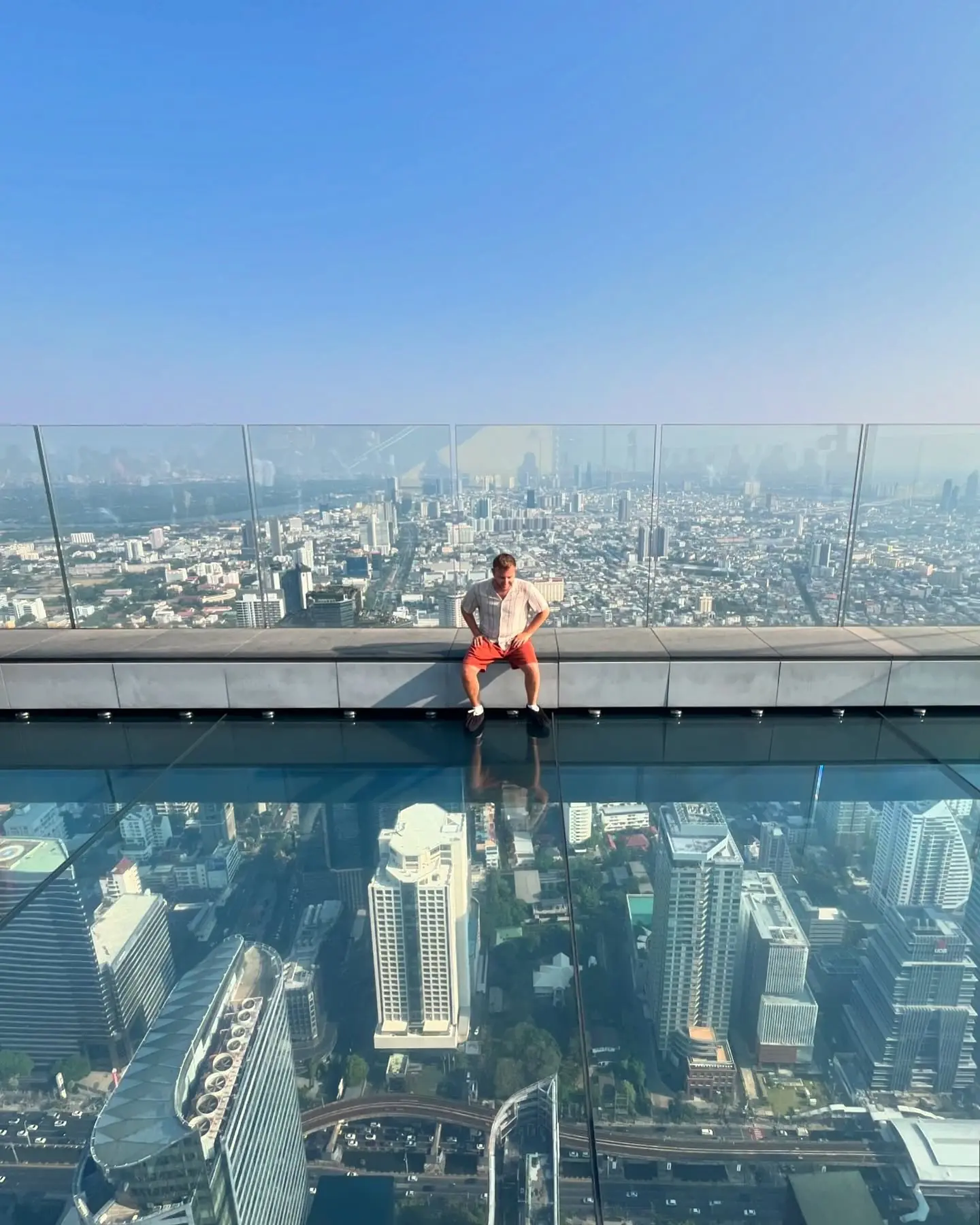 Sitting on the glass SkyWalk high above Bangkok