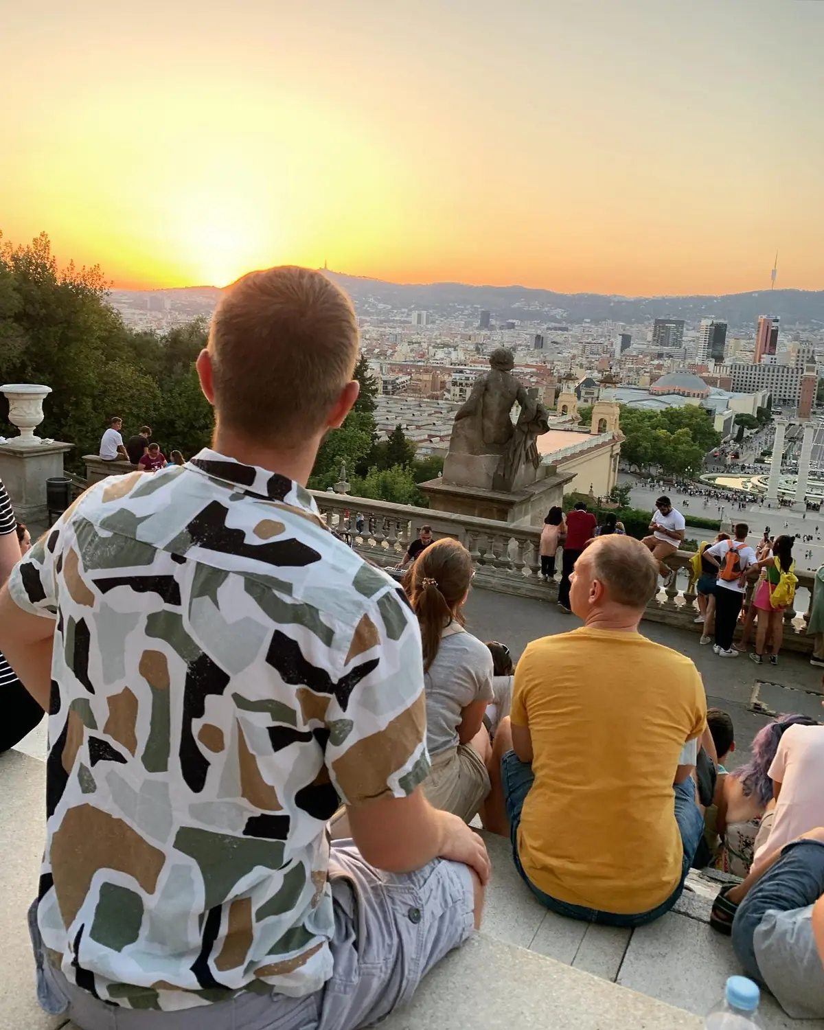 Andrew among a crowd watching the sunset over Barcelona from the Montjuïc terrace