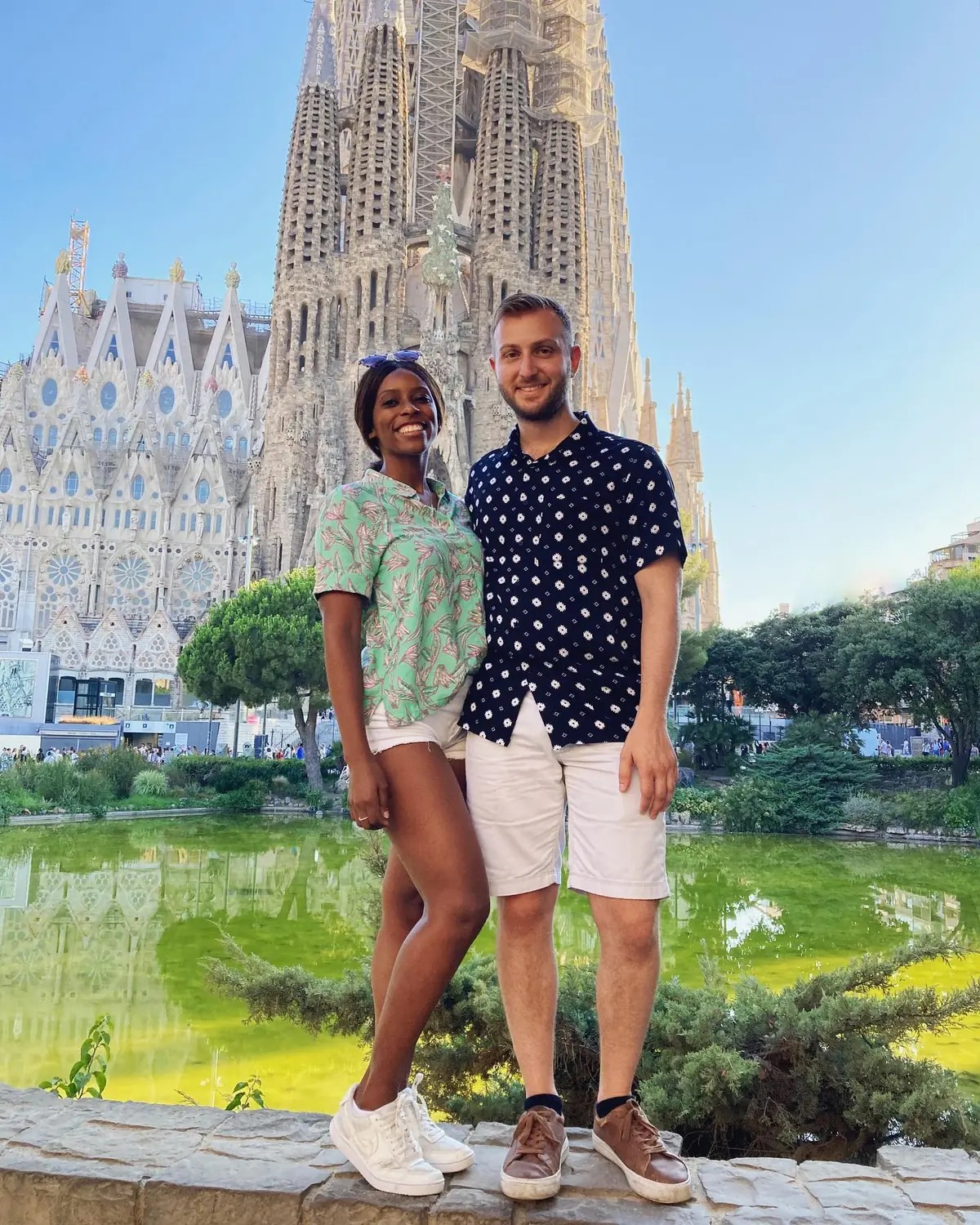 Us in front of the Sagrada Família with its towers rising behind the reflecting pond in Barcelona