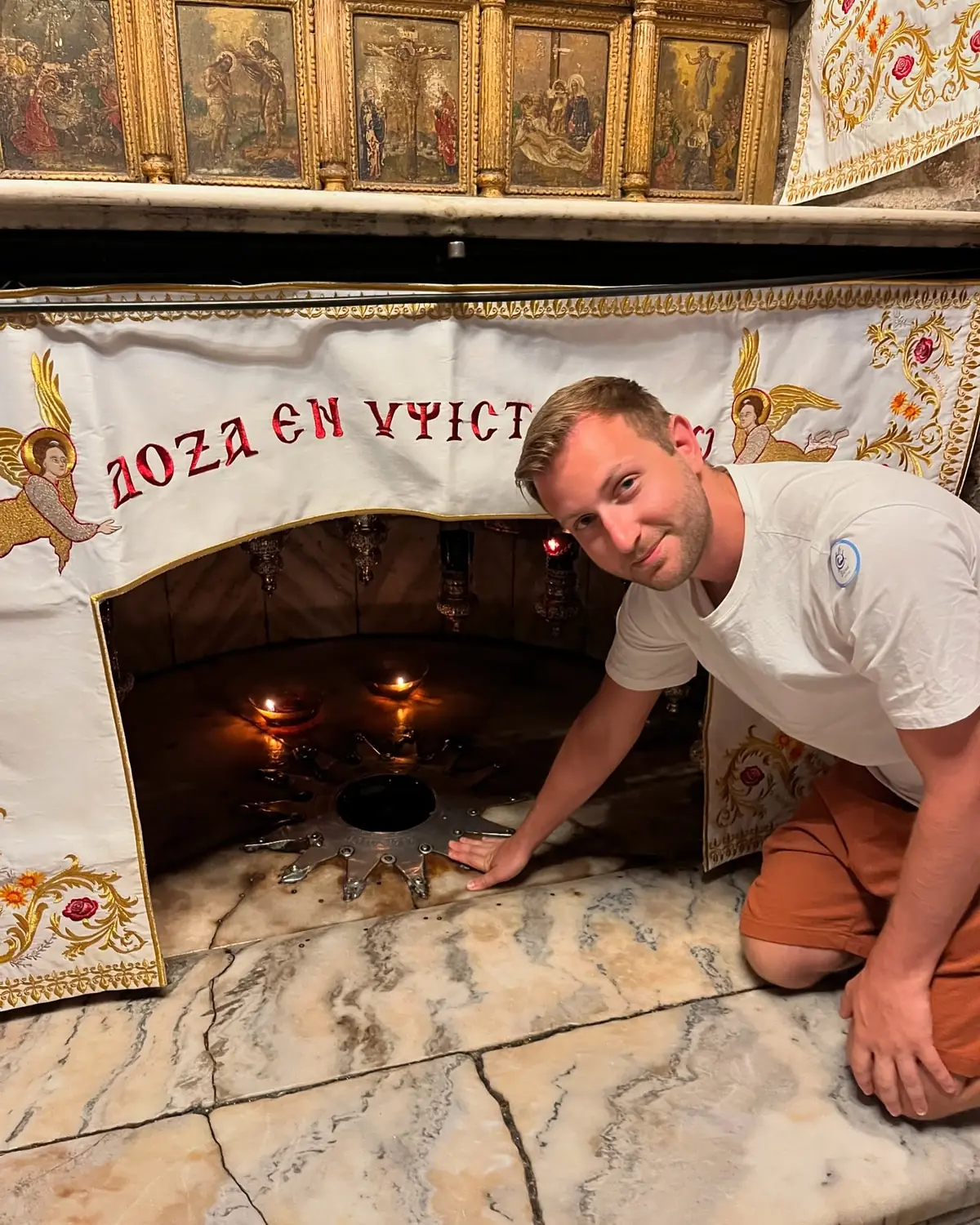 Andrew kneeling at the silver star marking the birthplace in the Grotto of the Nativity