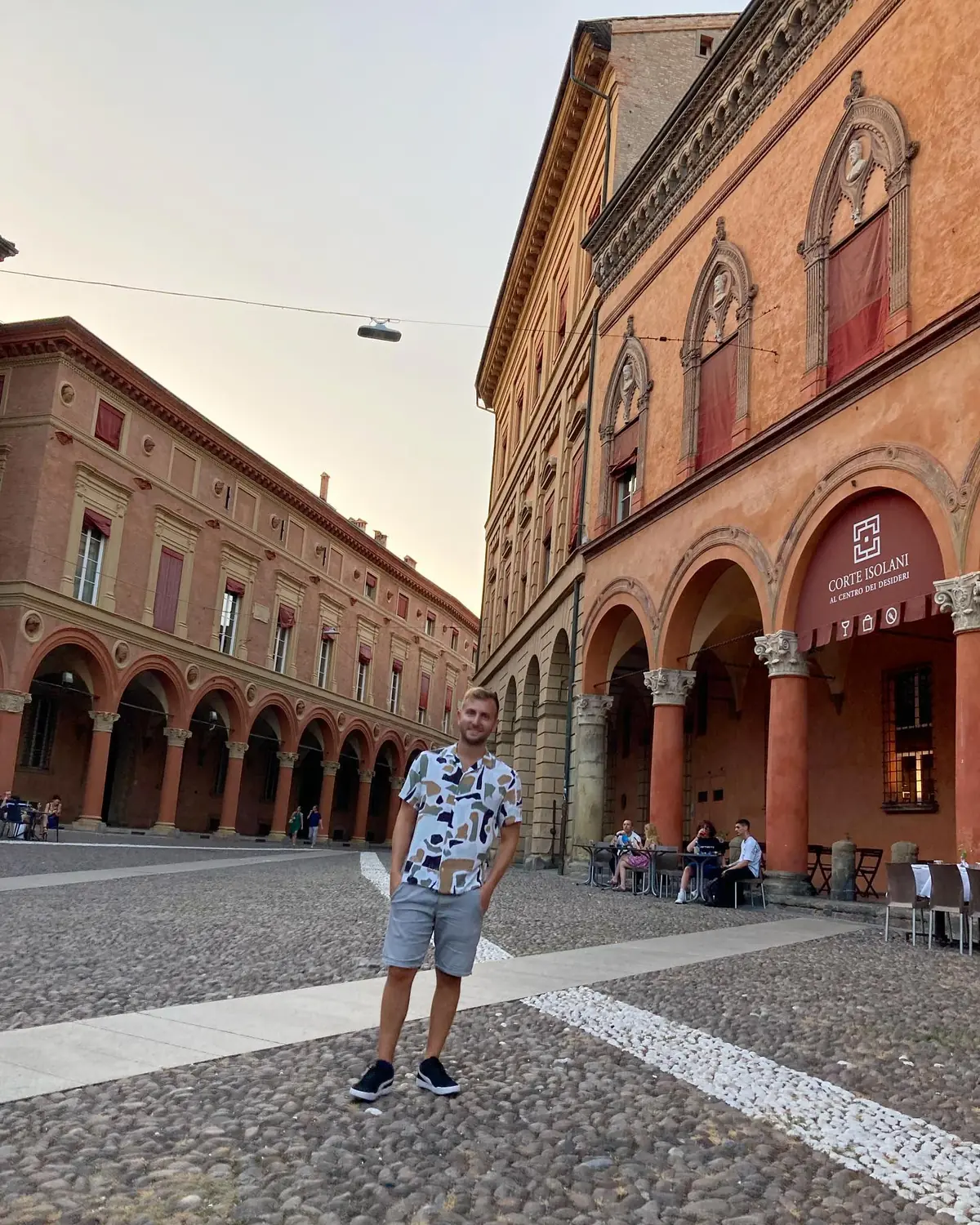 Andrew in a warm-toned Bologna square by the Corte Isolani arcade