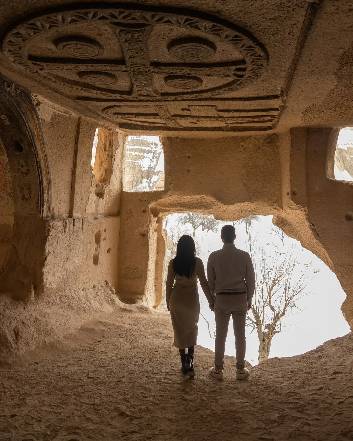 Us holding hands beneath an intricately carved cave-church ceiling