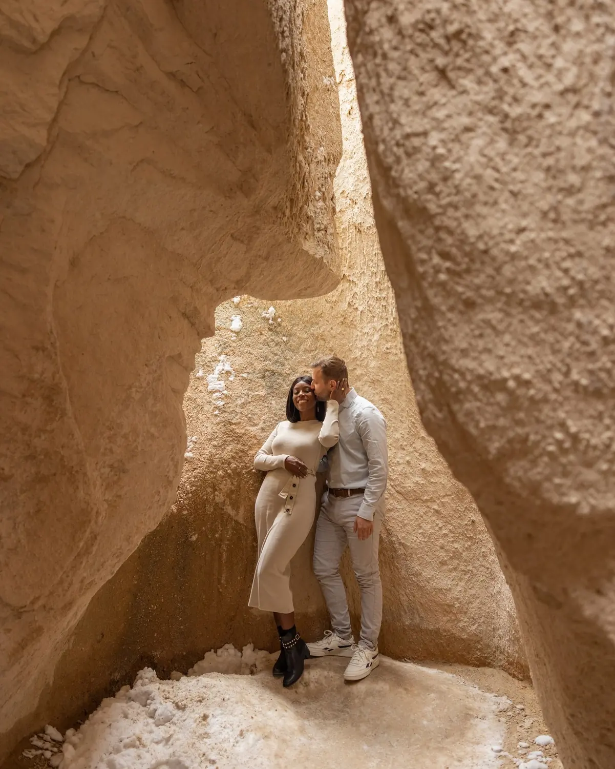 Andrew kissing Melody's forehead inside a towering sandstone slot canyon