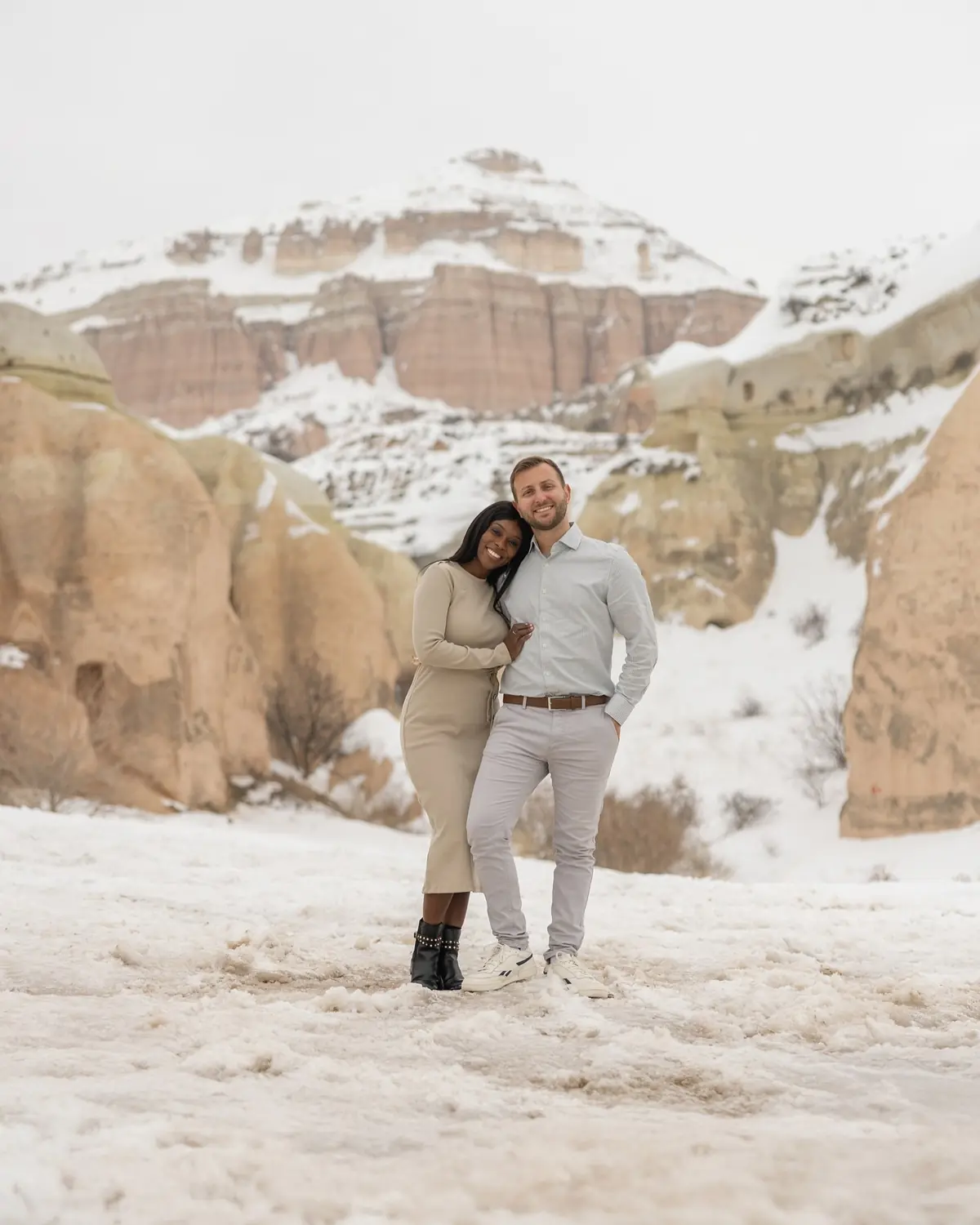 Us with a snow-capped rock mountain rising behind us in Cappadocia