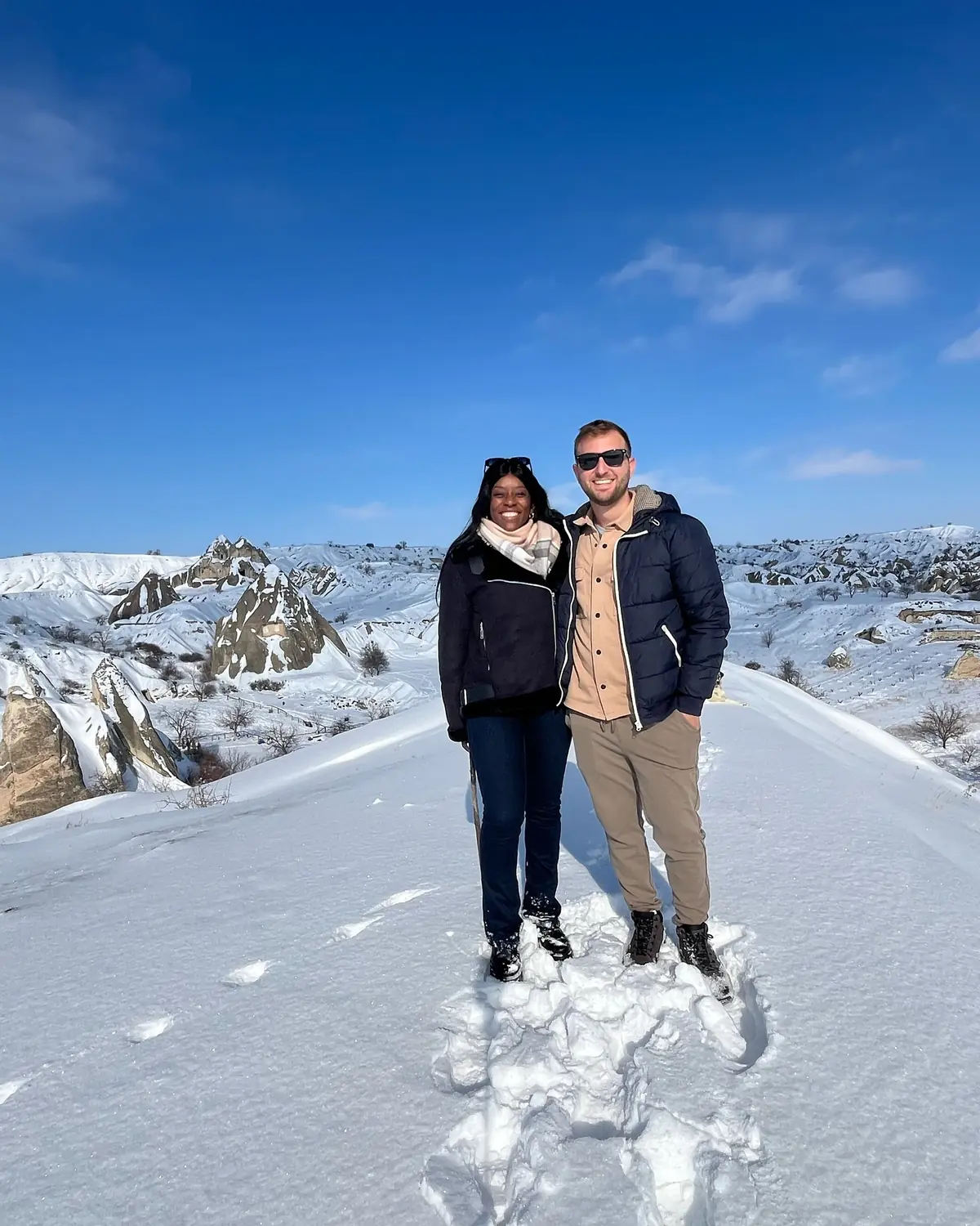 Us on a snowy ridge above a valley of fairy chimneys in Cappadocia