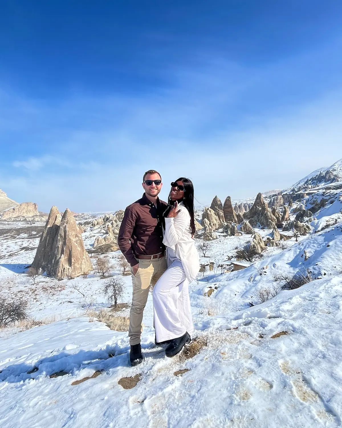 Us standing together in a snowy valley of fairy chimneys in Cappadocia, Turkey