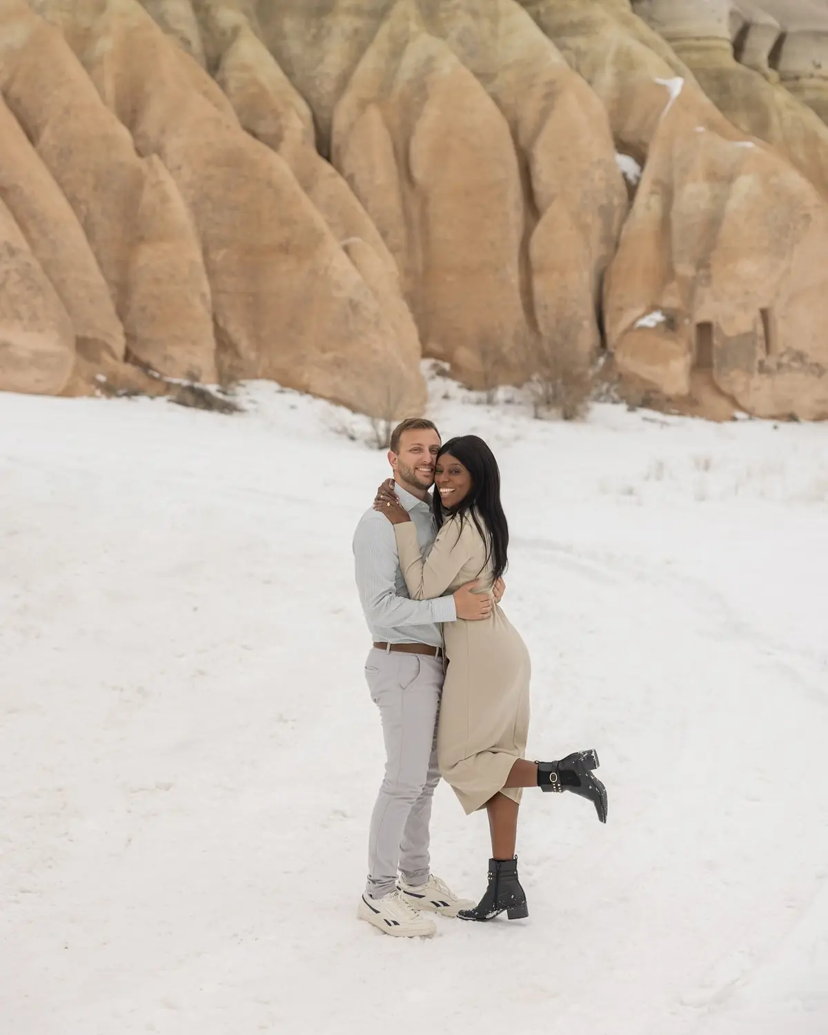 Us hugging in a snowy valley of fairy chimneys, Melody kicking up a heel