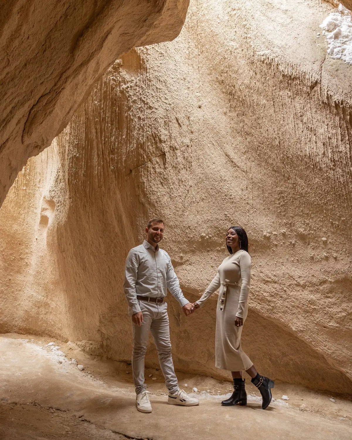 Us in a carved underground-city tunnel lit by warm light in Cappadocia