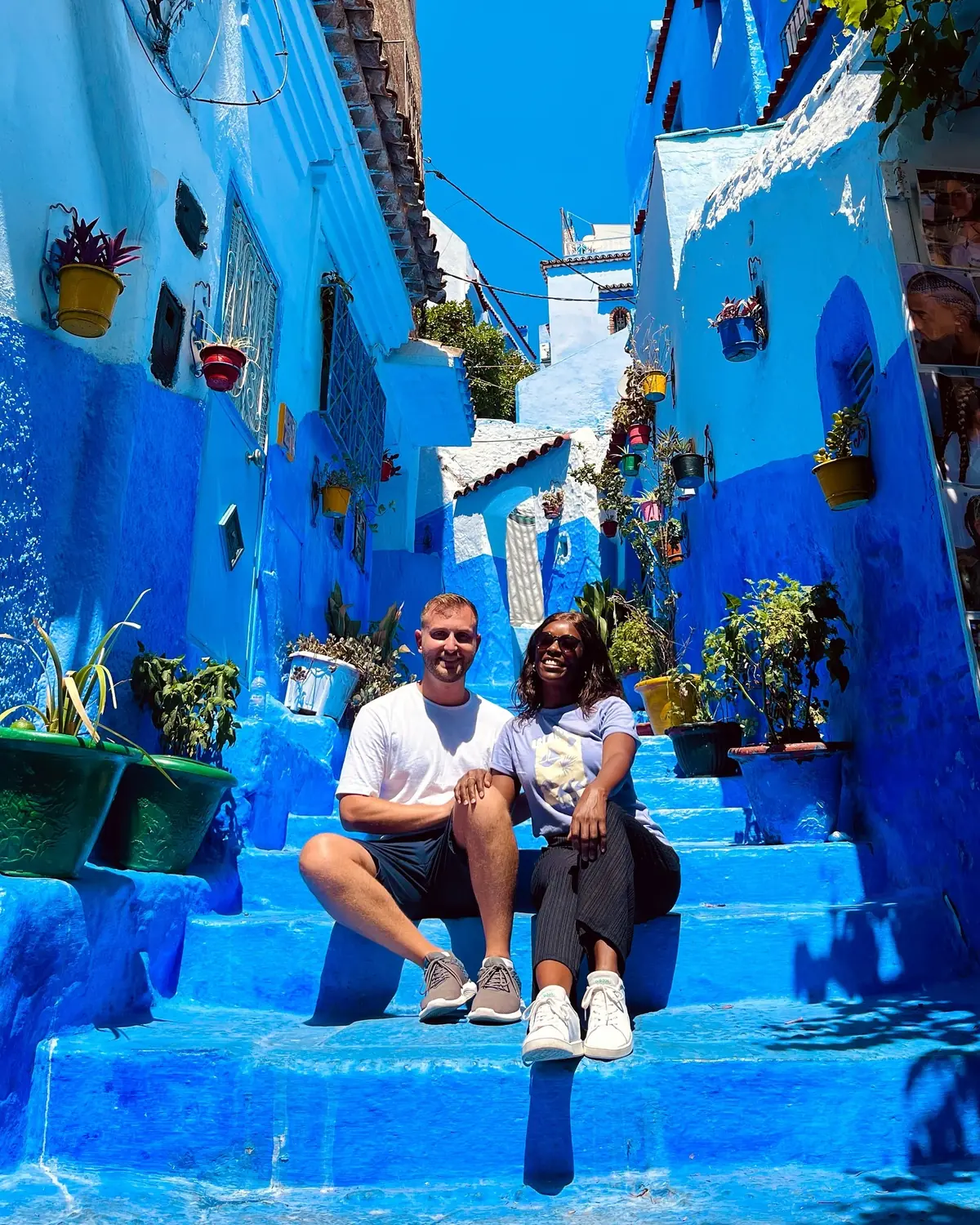 Us sitting together on blue steps lined with colourful potted plants