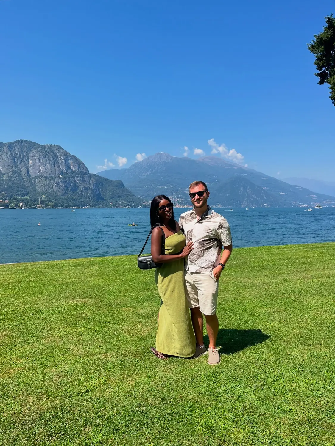 Us on a lakeside lawn at Bellagio with the mountains behind