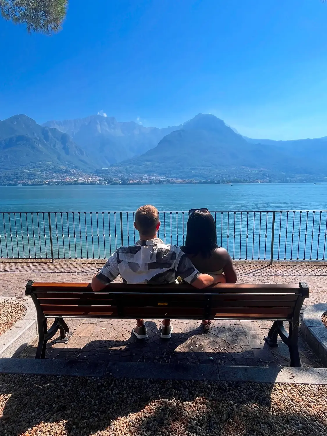Us on a lakeside bench looking out over the water and mountains
