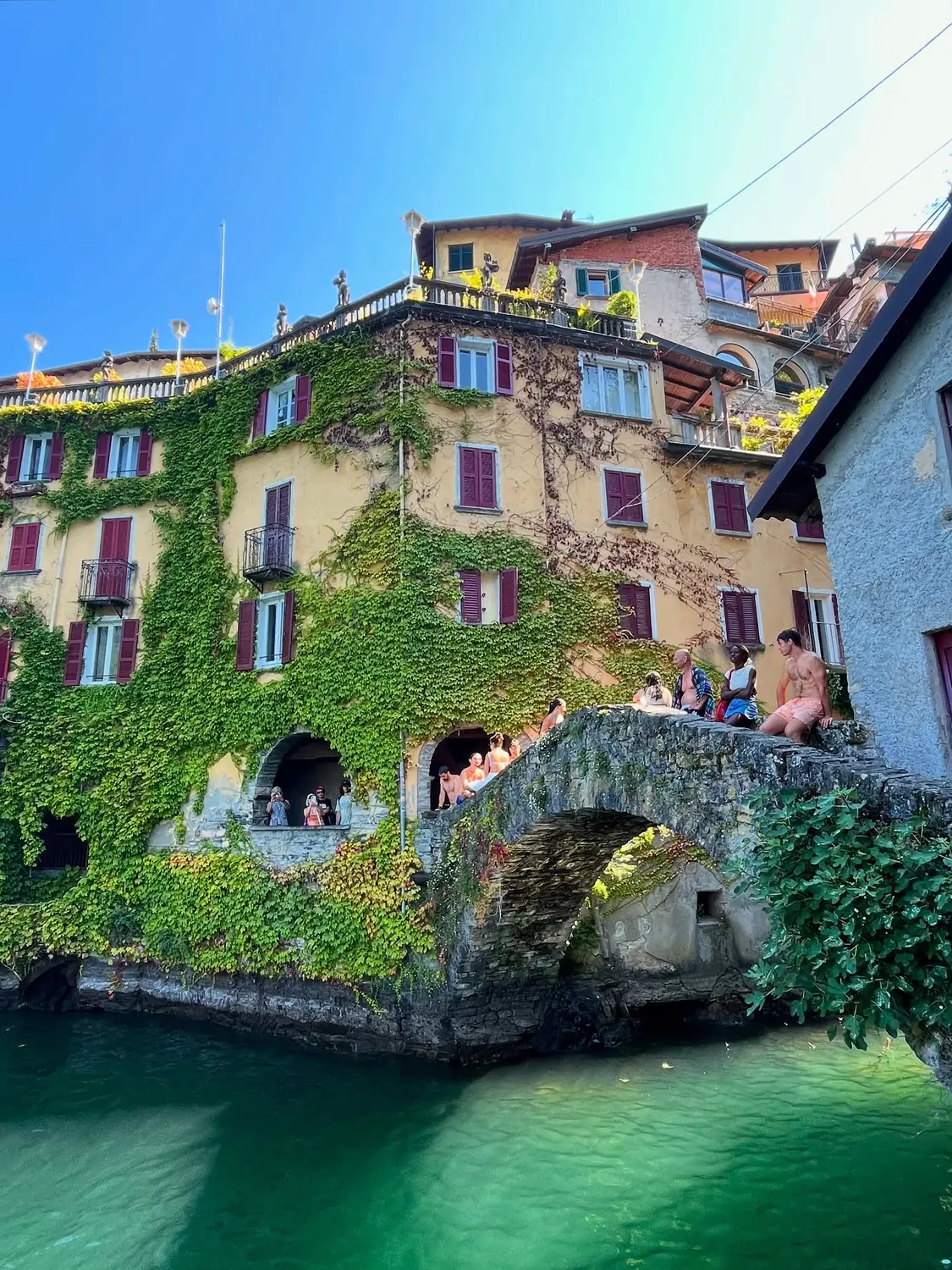 The ivy-covered houses and old stone bridge over the green gorge at Nesso