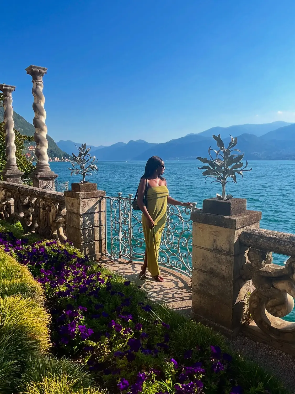 Melody on an ornate villa terrace jutting over Lake Como, mountains beyond