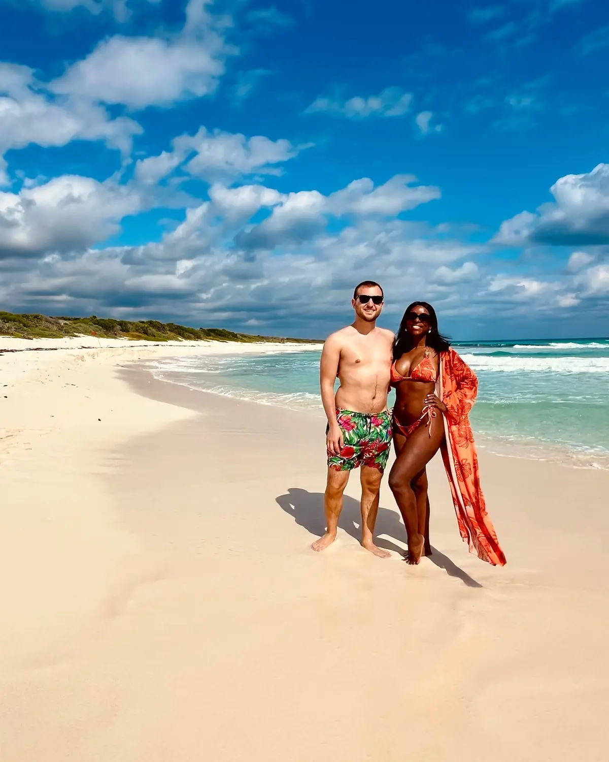 Us on a wide sandy Cozumel beach with turquoise water behind