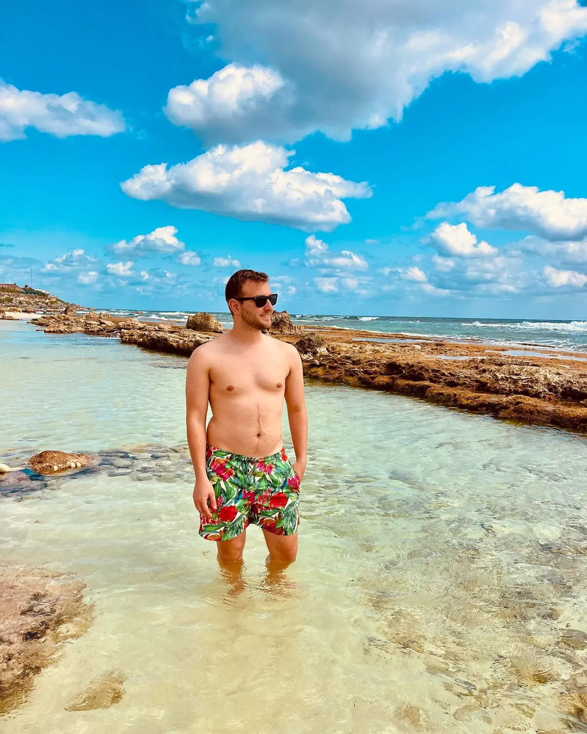 Andrew standing in a clear rocky tide pool on the Cozumel shore
