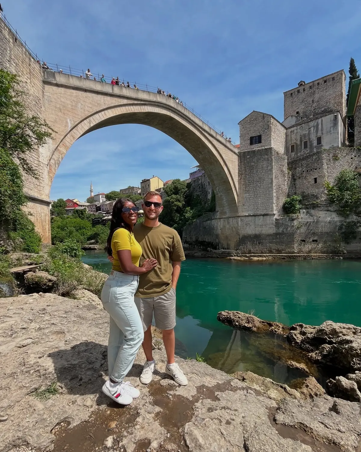Us standing on the rocks by the river directly under Mostar's Old Bridge