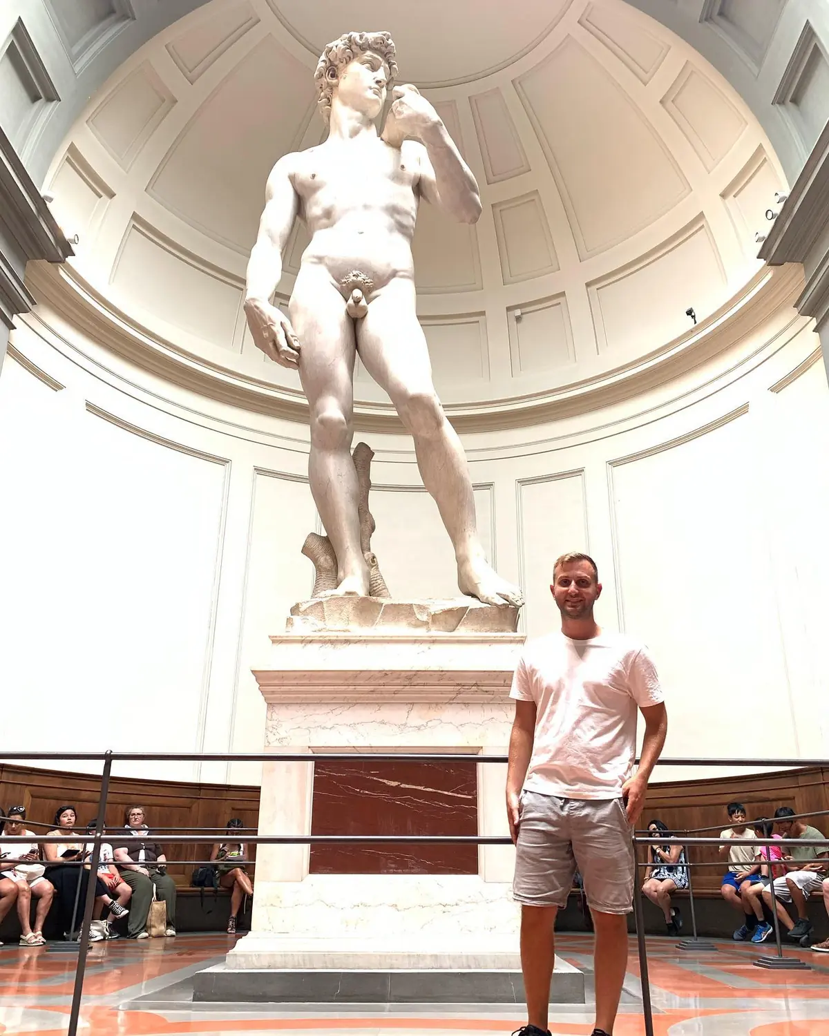 Andrew standing beside the towering David statue for scale