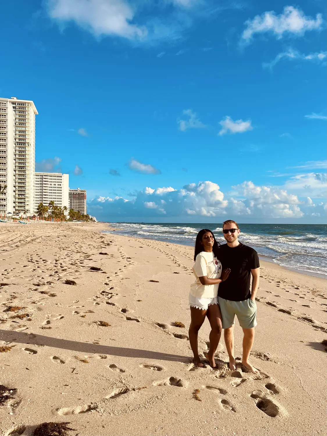 Us on the wide sandy Fort Lauderdale beach with high-rises behind
