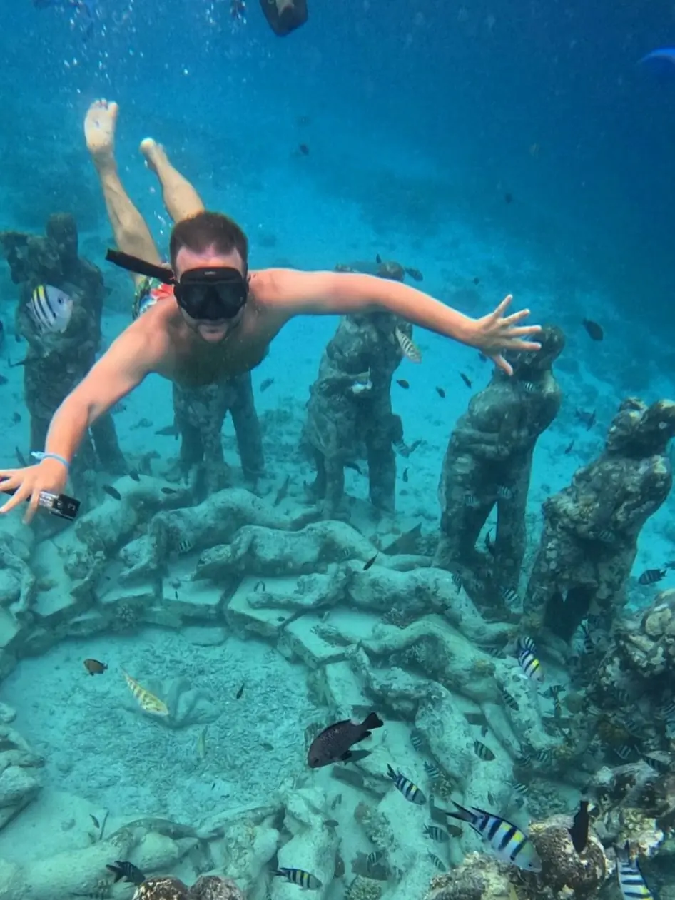 Snorkeler above the underwater ring of statues near the Gili Islands
