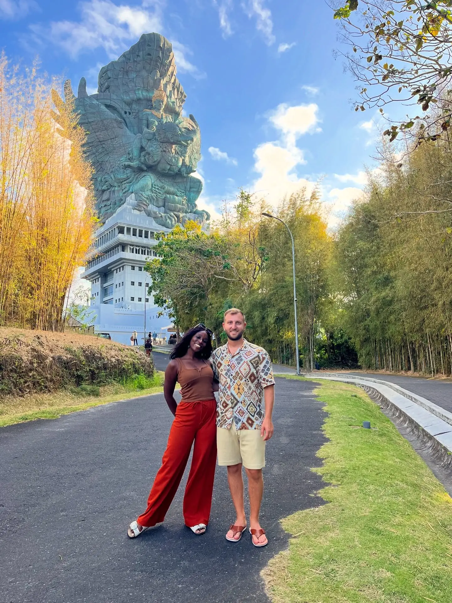 Couple on the approach road with the towering Garuda Wisnu Kencana statue