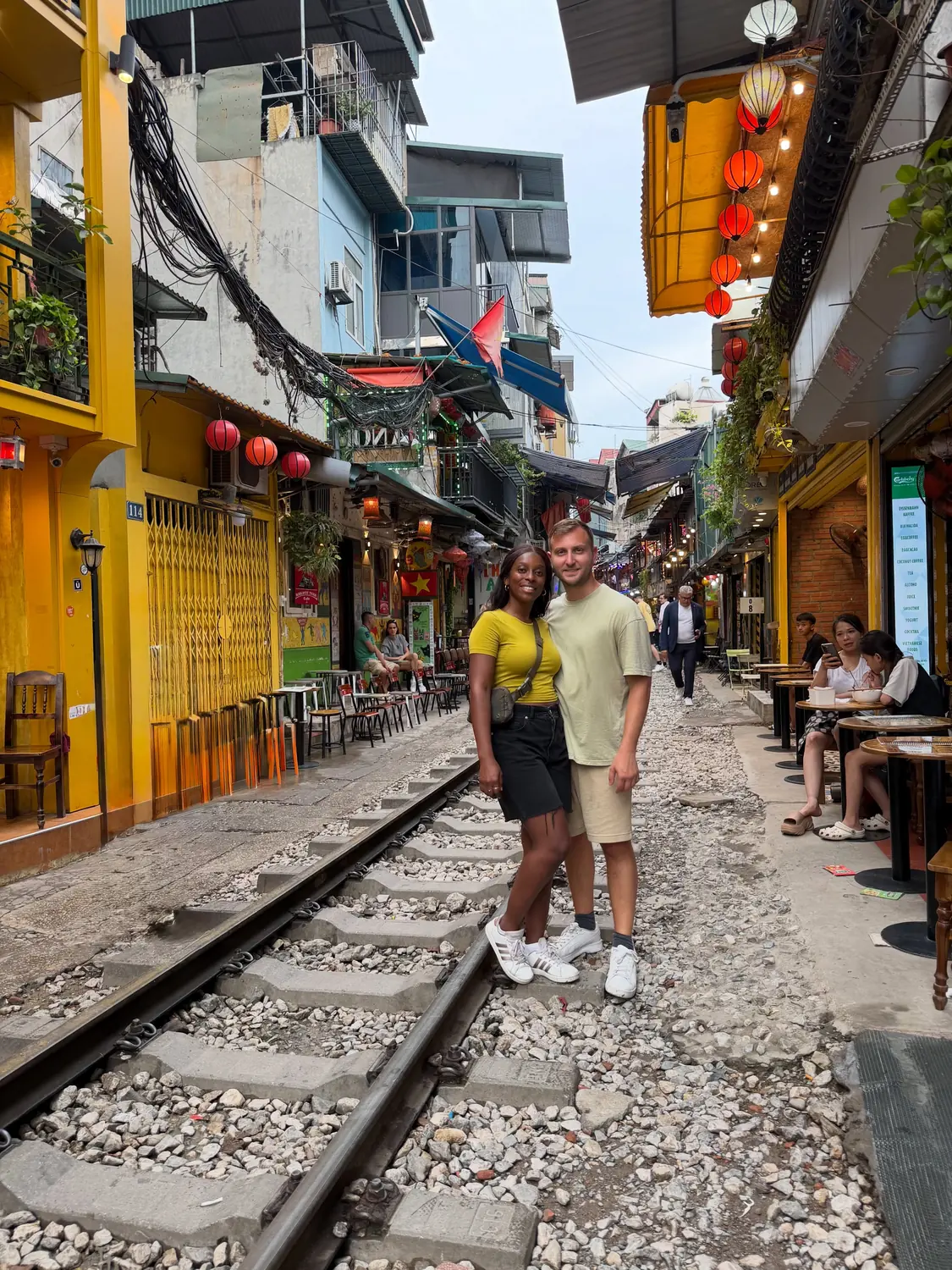 Us standing between the rails on Hanoi Train Street by day