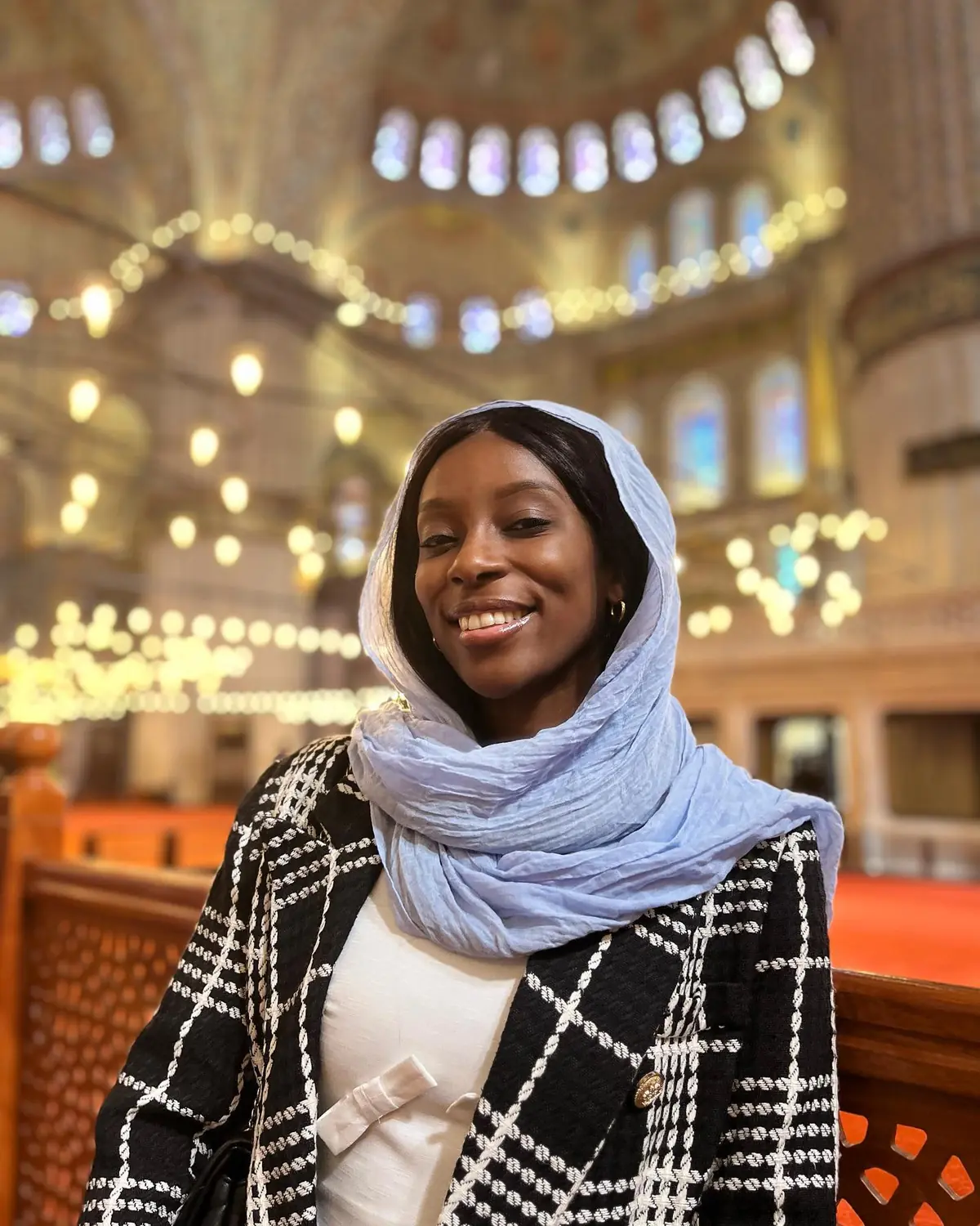 Melody in a blue headscarf inside the softly lit Blue Mosque