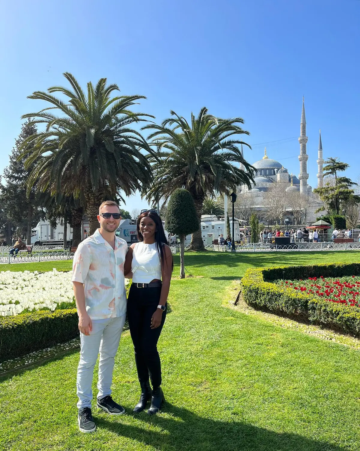 Us in a Sultanahmet garden with tulip beds and the Blue Mosque behind