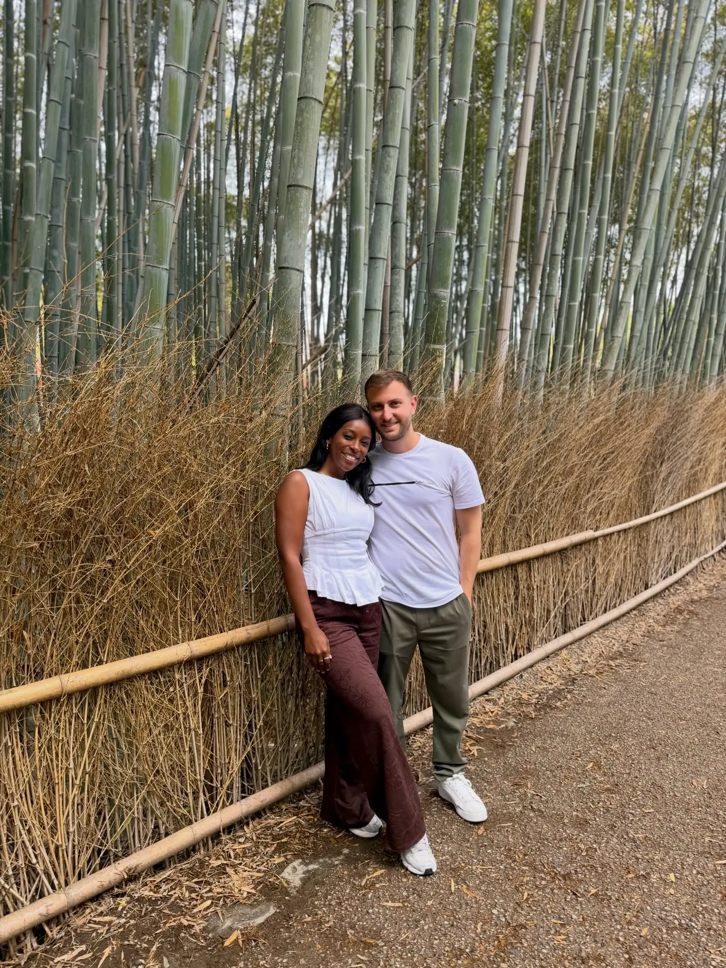 Us leaning against the bamboo fence in the Arashiyama grove