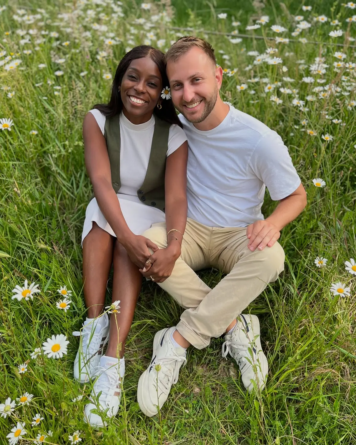 Us sitting together in a field of daisies