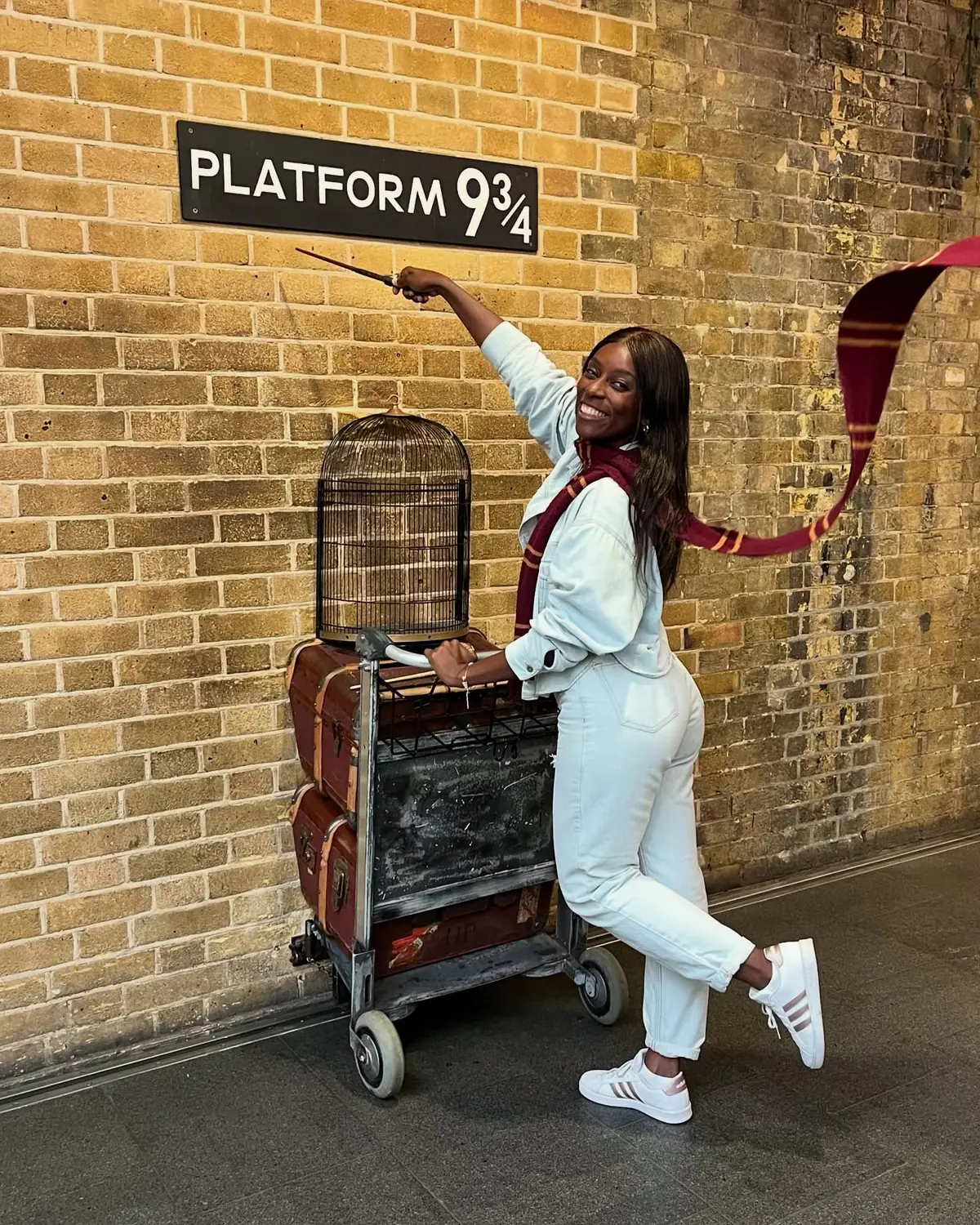 Melody with a flying Gryffindor scarf and wand at the Platform 9¾ trolley