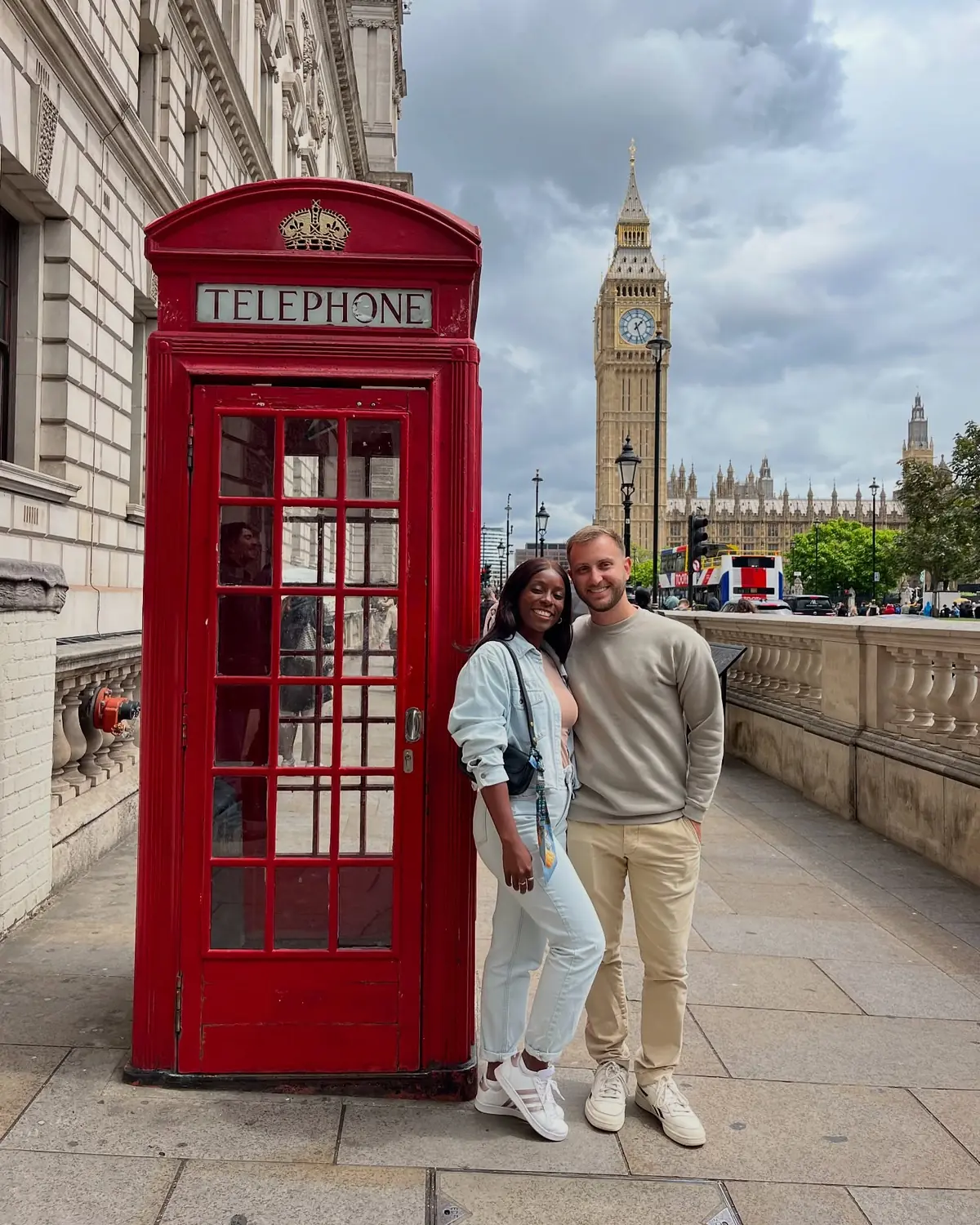 Us by a red telephone box with Big Ben and the Houses of Parliament behind, London