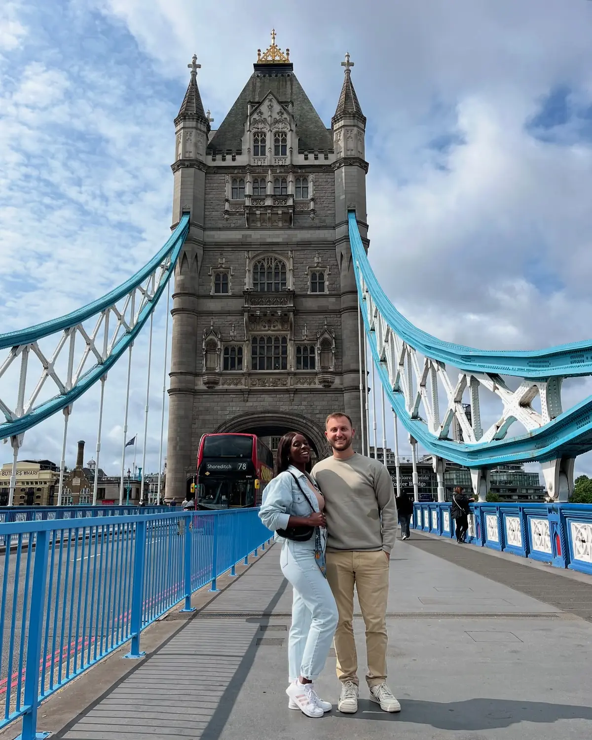 Us standing on Tower Bridge with its blue-and-white towers rising above us