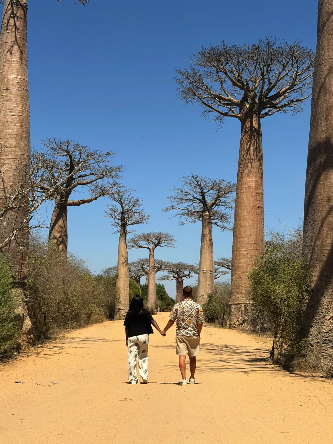 Us walking hand in hand down the Avenue of the Baobabs, Madagascar