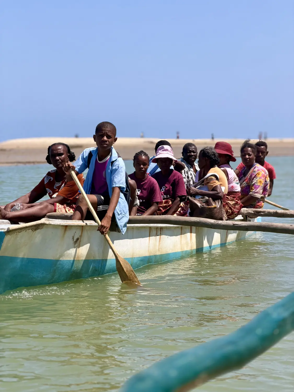 Villagers crossing the water in a wooden outrigger pirogue near Betania