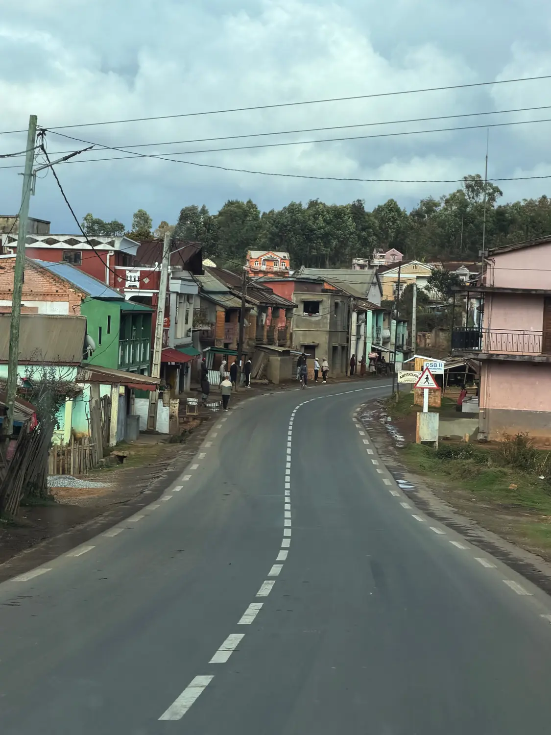 The single highway curving through a colourful highland village on the drive west across Madagascar