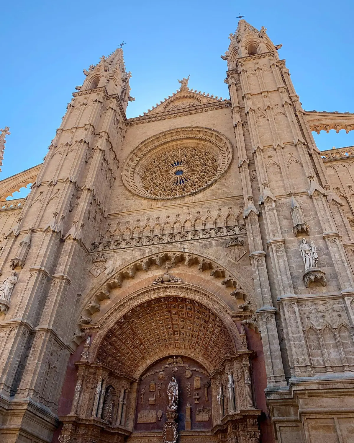 Looking up at the vast Gothic facade and rose window of Palma Cathedral (La Seu), Mallorca