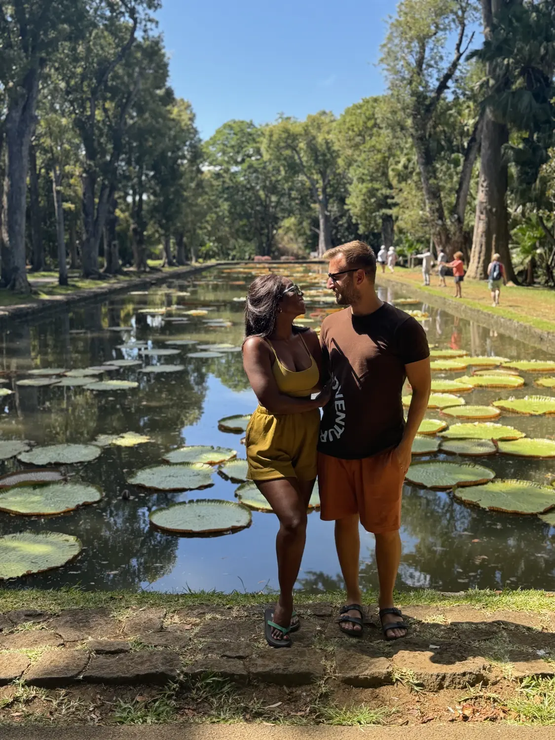 Us in front of a long pond full of giant Victoria water lilies at the botanical garden