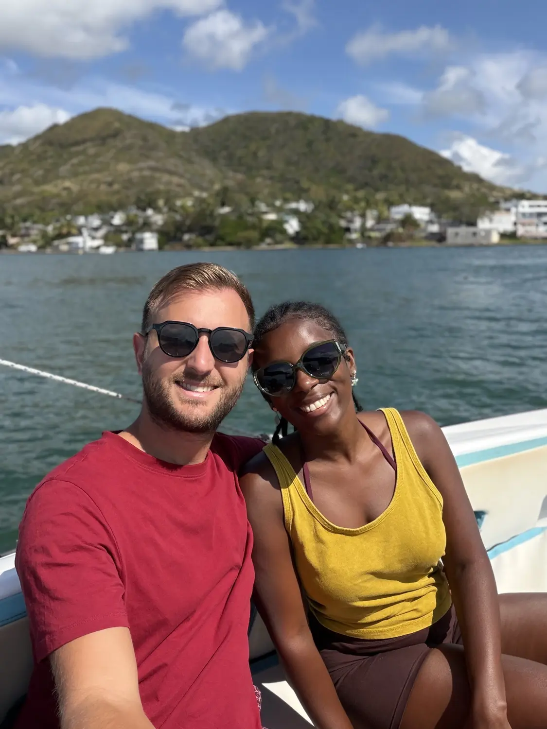 A selfie of us on the speedboat with green hills and the lagoon behind