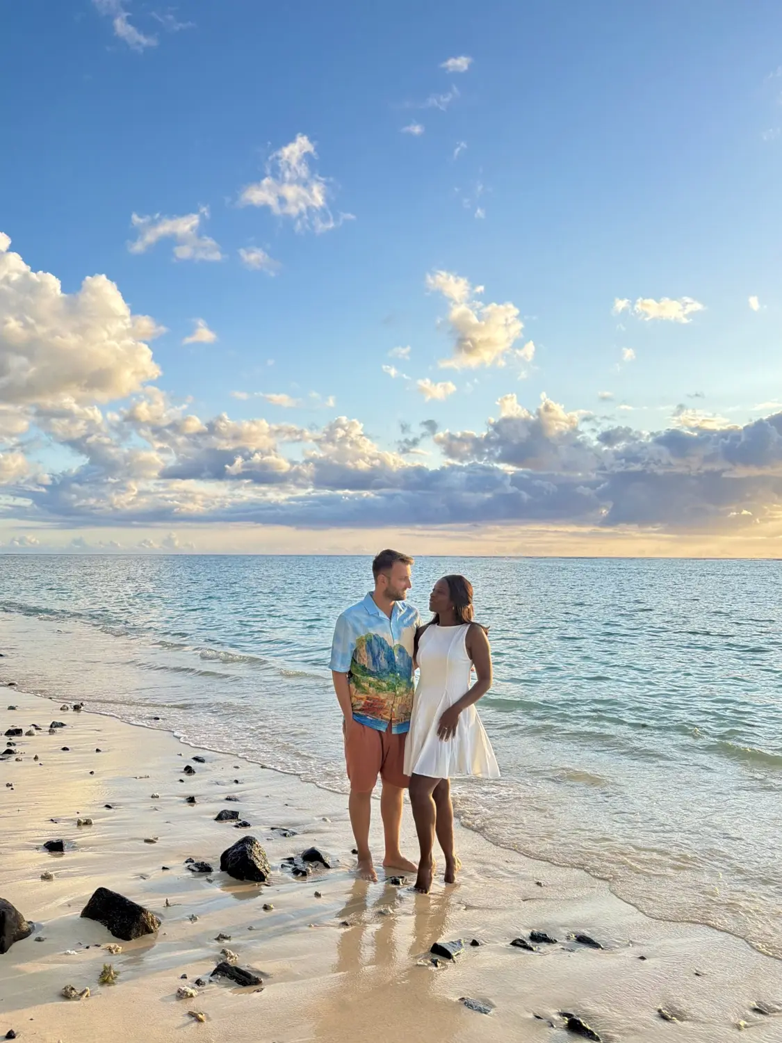 Us standing together at the water's edge under a pastel evening sky