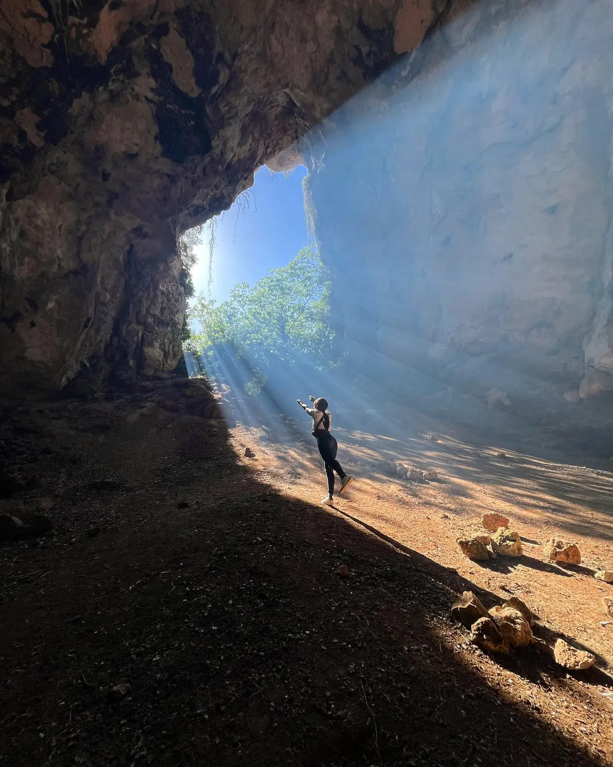 Melody dancing in a beam of light inside a coastal cave in Menorca