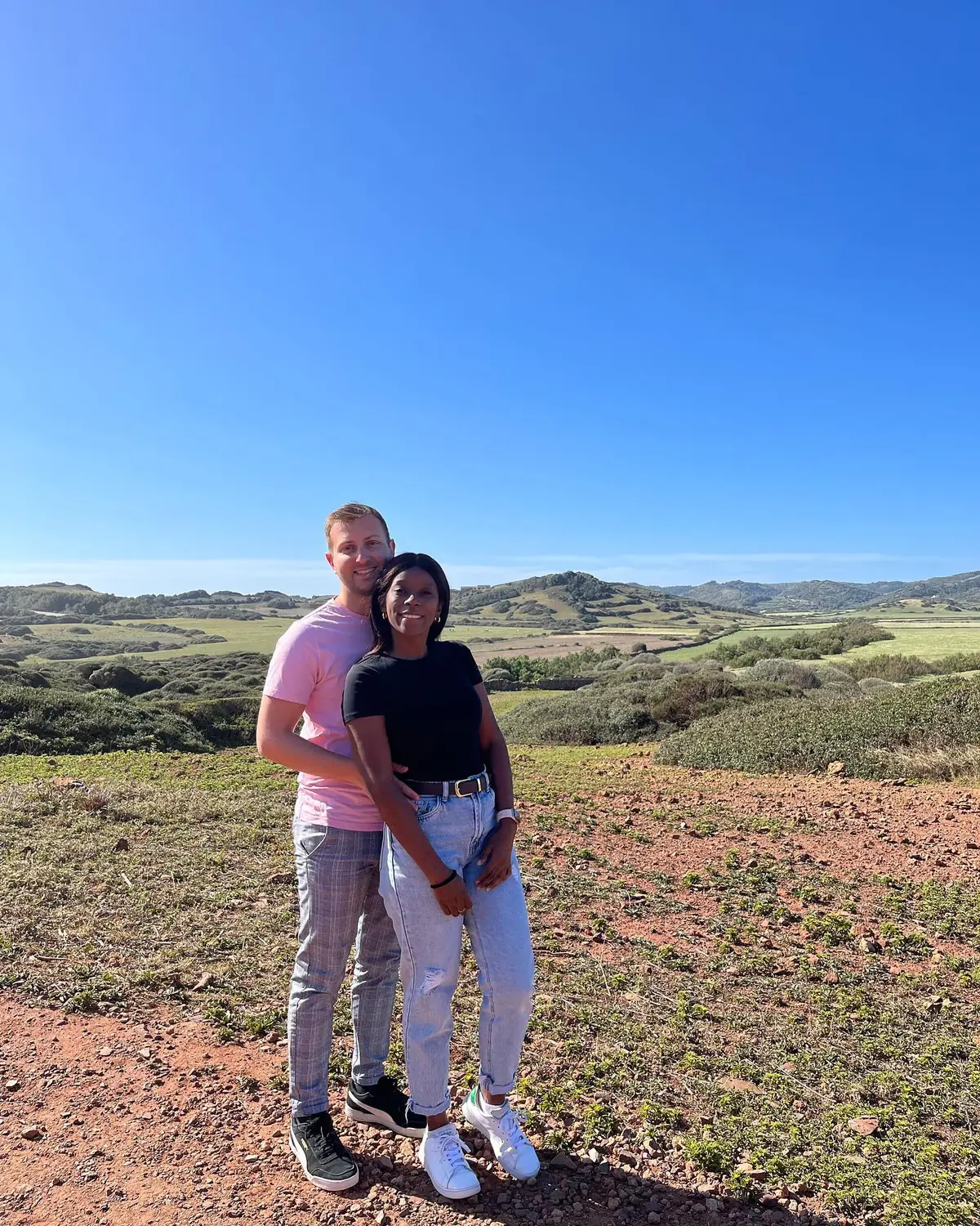 Us in the green, rolling countryside of inland Menorca under a bright blue sky
