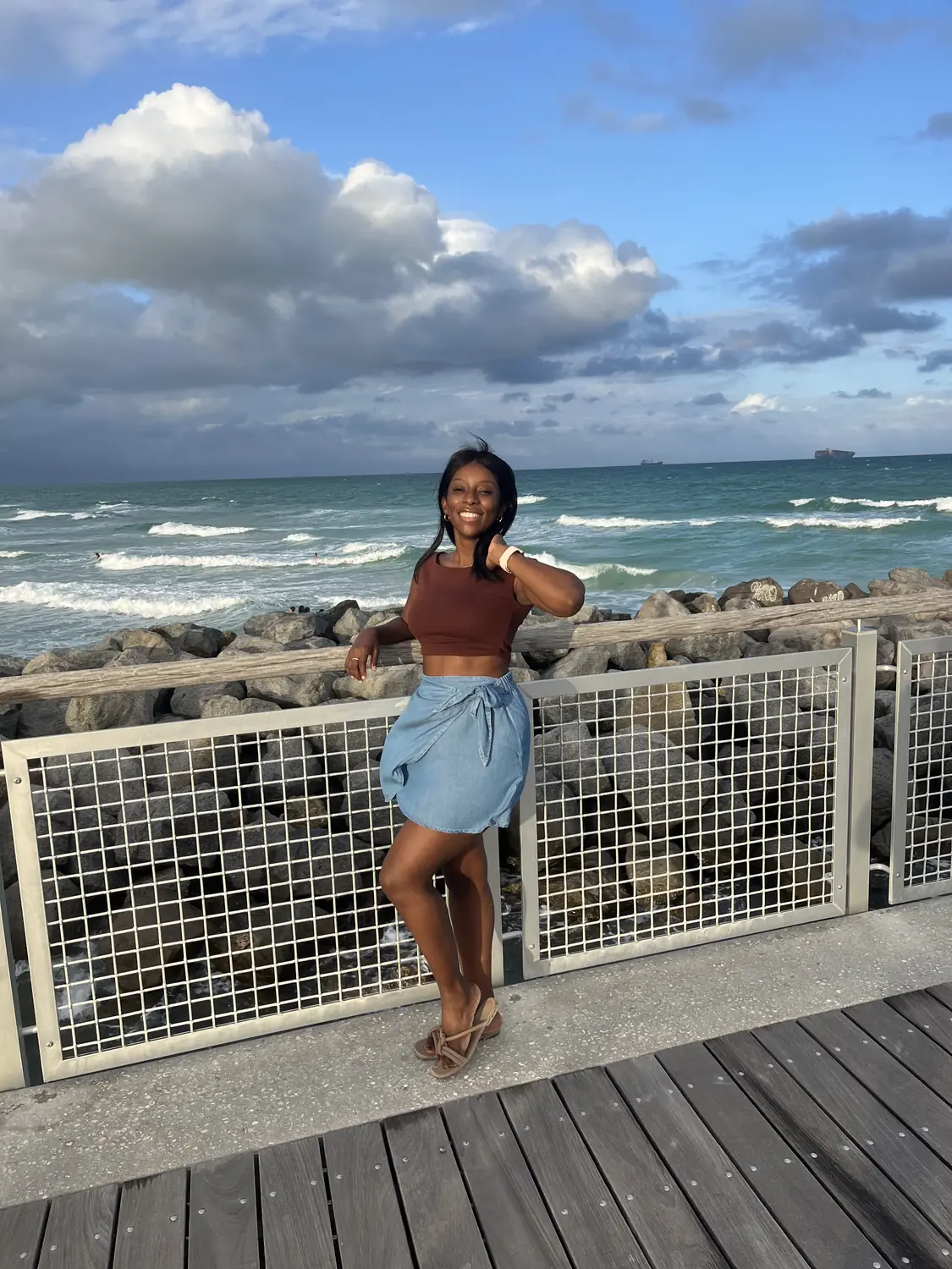 Melody at a boardwalk railing with the Miami Beach surf behind