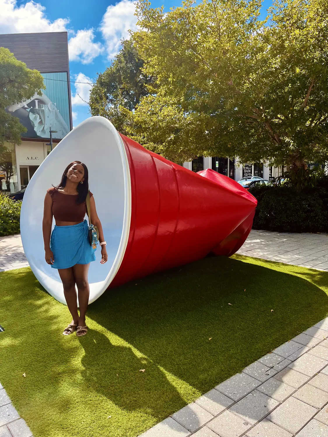 Melody posing inside a giant red cup sculpture in Wynwood, Miami