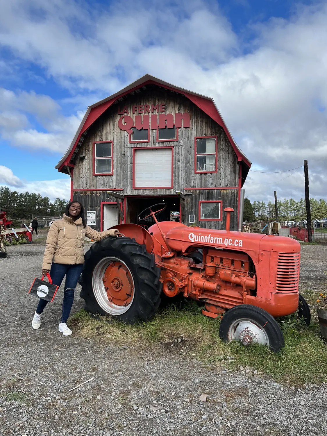 Us by a red barn and tractor at an apple orchard in Montreal's West Island