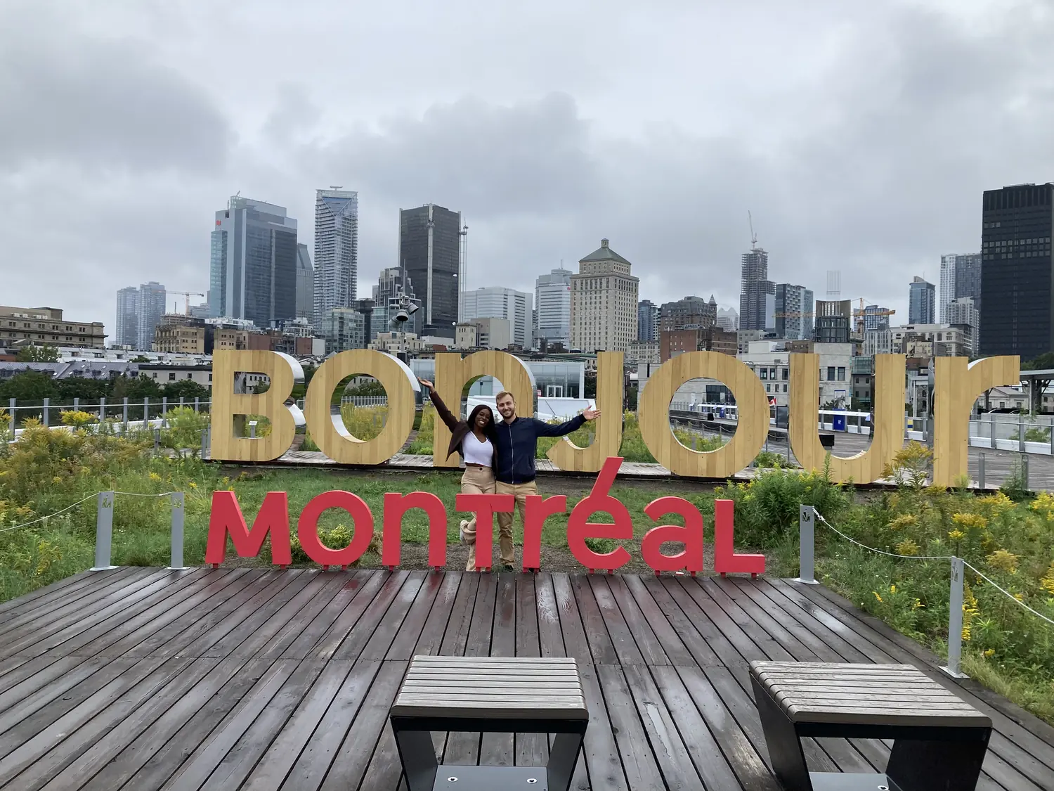 Melody at the Bonjour Montréal sign with the downtown skyline behind