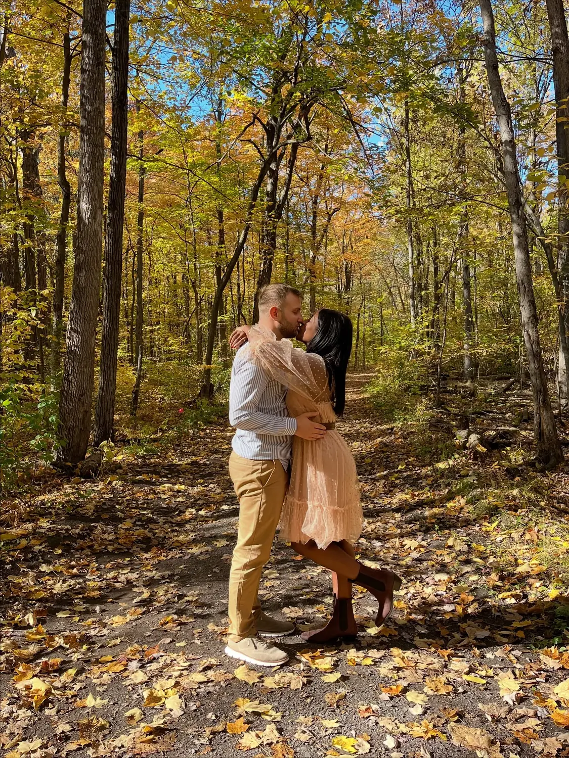 Us kissing on a leaf-covered forest trail near Sainte-Anne-de-Bellevue in autumn