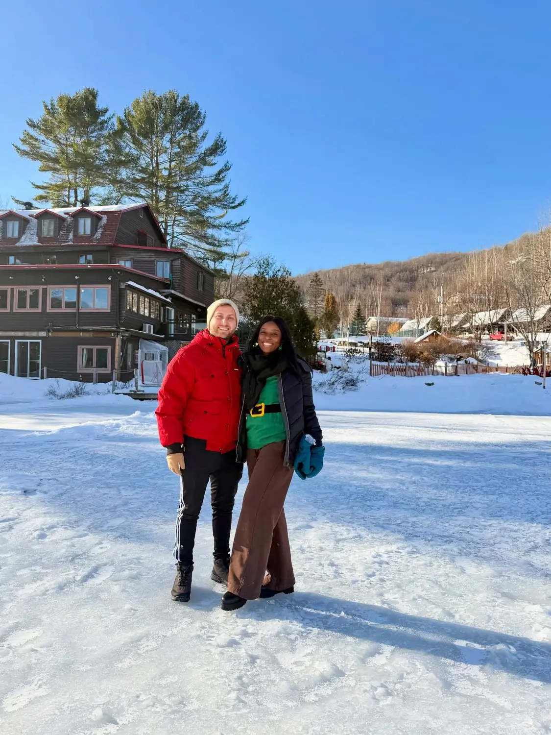 Couple on a frozen lake by a lodge